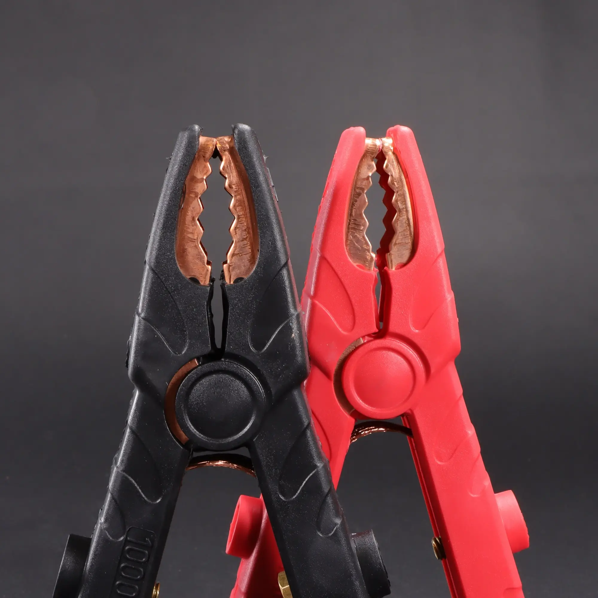 Jumper Cable Clamps, 1000amp black and red standing up on a black background